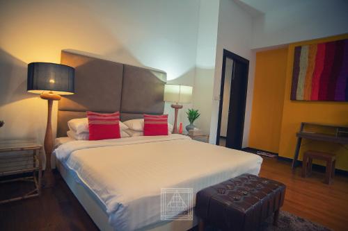 a bedroom with a large bed with red pillows at Baan Suan Residence เฮือนพักบ้านสวน in Chiang Mai