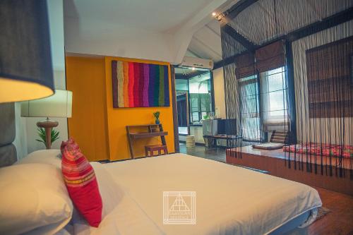a bedroom with a bed and a colorful wall at Baan Suan Residence เฮือนพักบ้านสวน in Chiang Mai