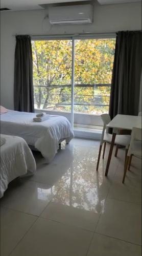 a bedroom with a bed and a large window at Aparts Magallanes in Presidente Derqui