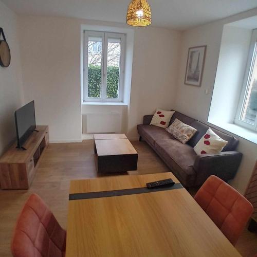 a living room with a couch and a table at La cachette du RDC in Seloncourt
