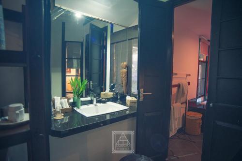 a bathroom with a sink and a mirror at Baan Suan Residence เฮือนพักบ้านสวน in Chiang Mai