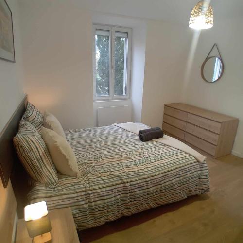 a small bedroom with a bed and a window at La cachette du RDC in Seloncourt