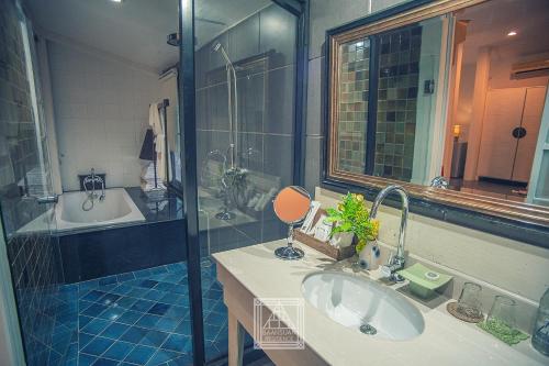 a bathroom with a shower and a sink and a tub at Baan Suan Residence เฮือนพักบ้านสวน in Chiang Mai