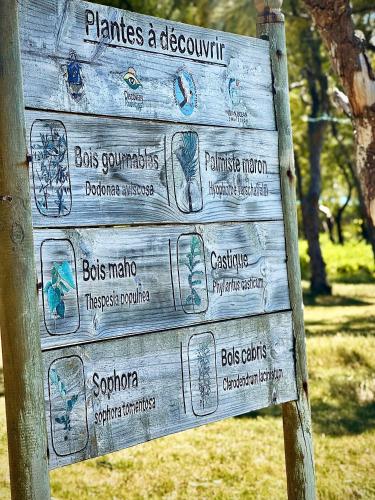 a wooden sign with drawings on it in a park at Villa Océan Gravier Rodrigues in Mt Bois Noir