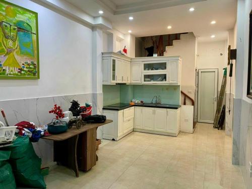 a kitchen with white cabinets and a wooden table at HnHome89TL in Hanoi