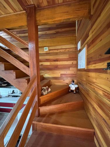 a wooden staircase in a room with wooden walls at Aconchego e Tranquilidade in Lages