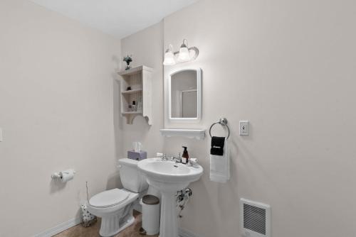 a white bathroom with a toilet and a sink at Wapato Lake Waterfront Retreat in Manson