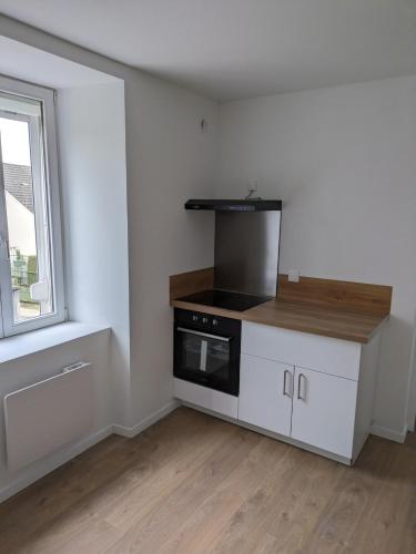 une cuisine vide avec une cuisinière et une fenêtre dans l'établissement T2 calme cosy rénové & entièrement équipé 1er étage, à Seloncourt