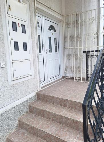 two white doors on a building with stairs at Atelier22 in Prilep