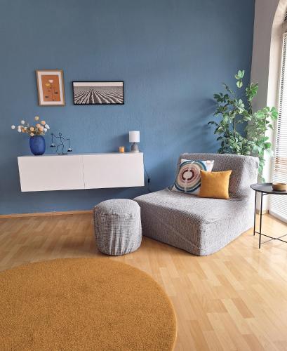 a living room with a chair and a blue wall at Atelier22 in Prilep