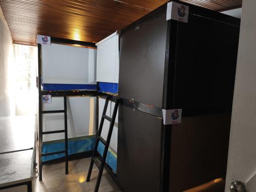 a room with a refrigerator and a ladder in a room at Ayllu Hostel in Bogotá