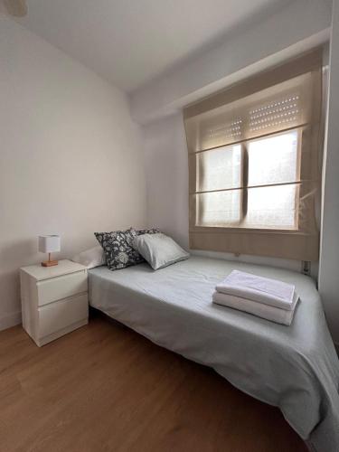 a small bedroom with a bed and a window at Cómodo apartamento a 5 minutos del centro in Santander