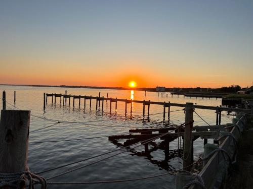 a sunset over a body of water with a dock at Private beach on a fenced in property sunset views in Hampton Bays