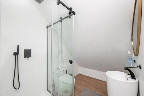 a bathroom with a glass shower and a toilet at Private beach on a fenced in property sunset views in Hampton Bays