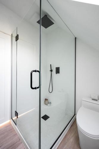 a glass shower door in a bathroom with a toilet at Private beach on a fenced in property sunset views in Hampton Bays