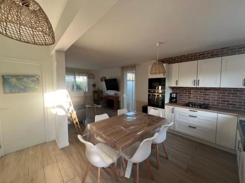 une cuisine avec une table en bois et des armoires blanches dans l'établissement Konk Kerne Home, à Concarneau