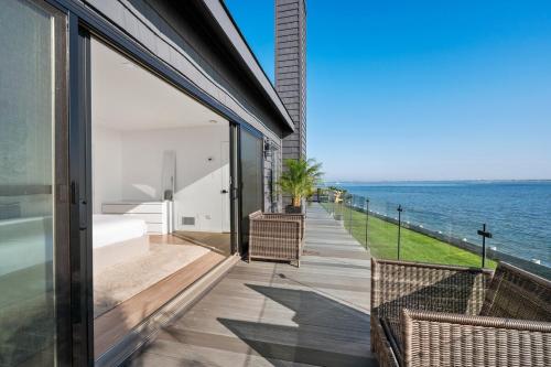 a house with a view of the ocean at Private beach on a fenced in property sunset views in Hampton Bays