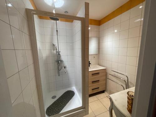 une salle de bain avec une douche avec une porte vitrée dans l'établissement Appartement 4* en résidence privée, à Châtel-Guyon