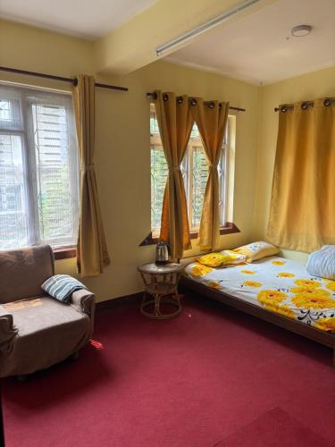 una camera da letto con un letto, una sedia e finestre di Osho Gaurishankar Meditation Center a Kathmandu