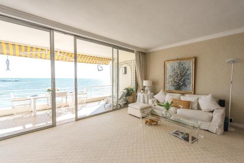 un salon avec un canapé et une vue sur l'océan dans l'établissement Beach front magnificent apartment Cote d'Azur Eden Beach, à Antibes