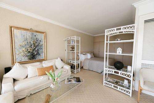 un salon avec un canapé et un lit dans l'établissement Beach front magnificent apartment Cote d'Azur Eden Beach, à Antibes