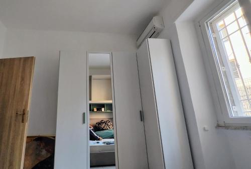 a room with two white cabinets and a window at OstiaByTheSeaCozyBedroom in Lido di Ostia