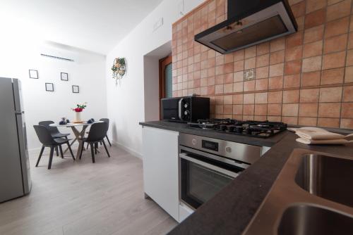 a kitchen with a stove and a table with chairs at Seaview, Mountains & Relax with TWO Private Pools - Rifugio Dorotea in Salerno