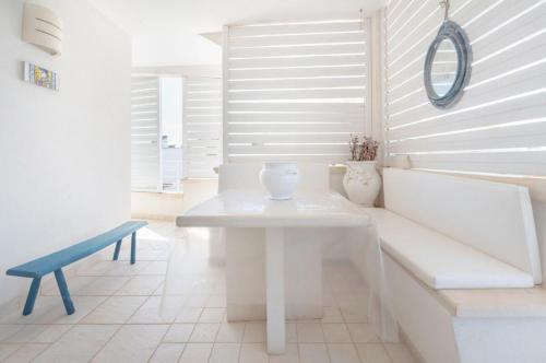 a white room with a white table and a blue bench at Le Terrazze in Otranto