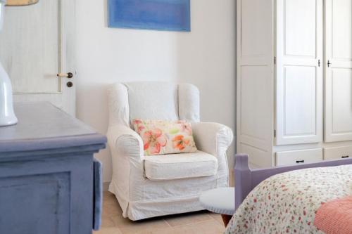 a white chair with a pillow in a bedroom at Le Terrazze in Otranto
