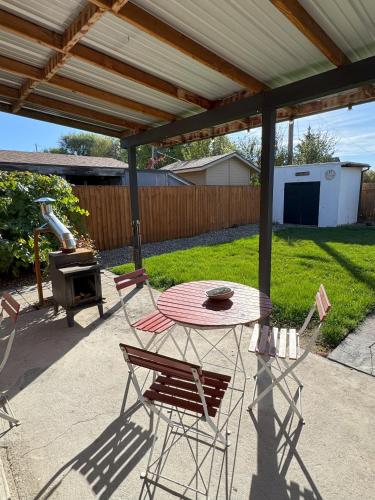 a patio with a table and chairs and a grill at Cabin 2BR 2BA home, 3 min to airport and downtown in Boise