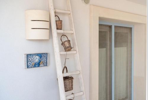a ladder leaning against a wall with baskets on it at Le Terrazze in Otranto