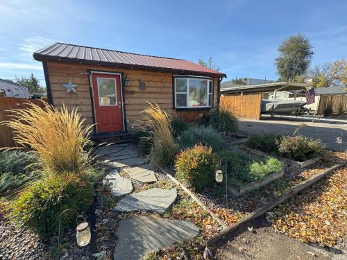 a tiny house with a red door in a yard at Cabin 2BR 2BA home, 3 min to airport and downtown in Boise