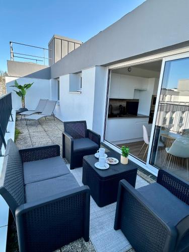 d'une terrasse avec des chaises et des tables sur un balcon. dans l'établissement Charmant T2 avec grande terrasse à proximité immédiate du centre ville, à Quimper