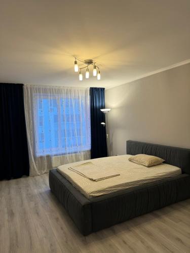 a bedroom with a bed in front of a window at Стильна і сучасна квартира з двома спальнями біля Дніпра! in Cherkasy