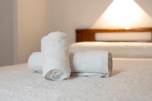 a stack of rolled towels on a bed at Hotel Pedro Torres in Cuenca