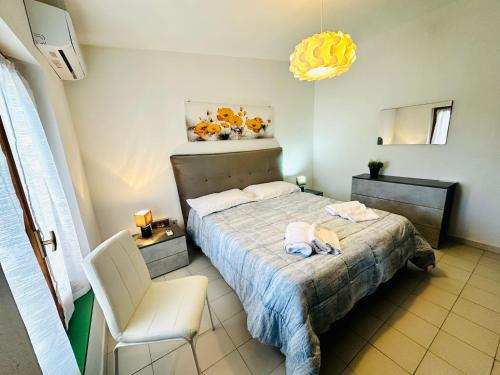a bedroom with a bed and a white chair at Villa Verde in Badesi