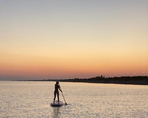 a man standing on a paddle board in the water at Chill Garden Experience B&B in San Pietro in Bevagna