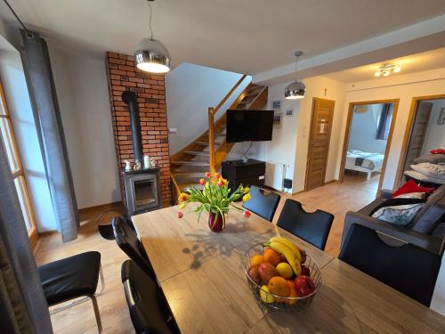 a dining room table with a bowl of fruit on it at Domek 4Seasons Karpacz z prywtną Sauną i Kominkiem in Karpacz