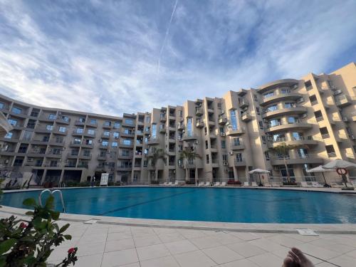 a large apartment building with a large swimming pool at princess Resort Hurghada in Hurghada