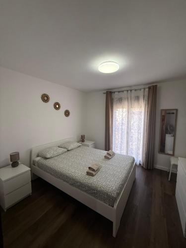 Un dormitorio blanco con una cama y una ventana. en Casa Amore, en Parque Holandes