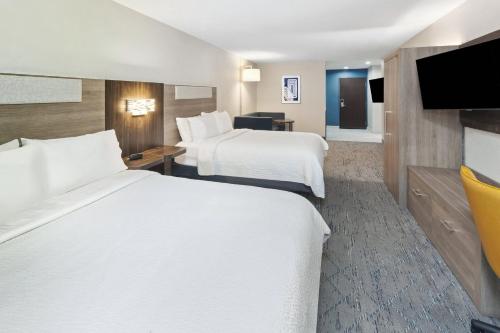 a hotel room with two beds and a flat screen tv at Holiday Inn Express Pekin - Peoria Area by IHG in Pekin Heights