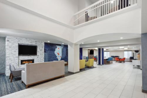 an office lobby with a fireplace and chairs at Holiday Inn Express Pekin - Peoria Area by IHG in Pekin Heights