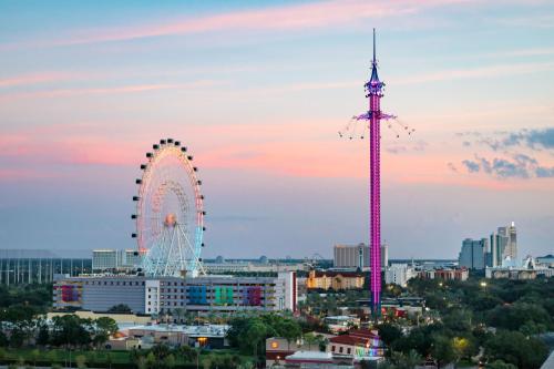 a ferris wheel in a city at sunset at The Point Hotel & Suites Universal in Orlando