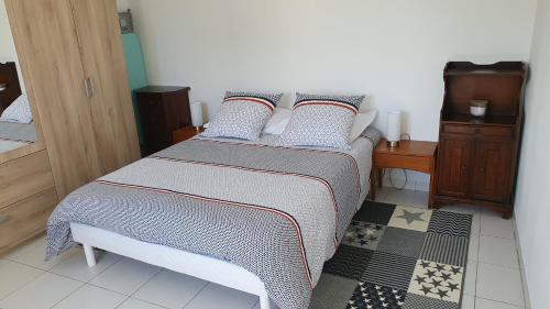 une chambre avec un lit avec des oreillers dessus dans l'établissement Maison individuelle calme, à La Turballe