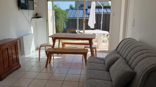 un salon avec un canapé et une table dans l'établissement Maison individuelle calme, à La Turballe