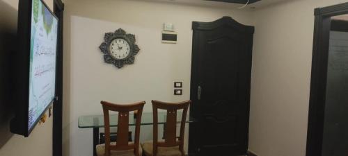 アレクサンドリアにあるEnjoy modern lovely entire studio in a fancy building with Free Wi-Fi & AC and Flat screen TV in Loran in the heart of Alexandriaのテーブル(椅子2脚付)
