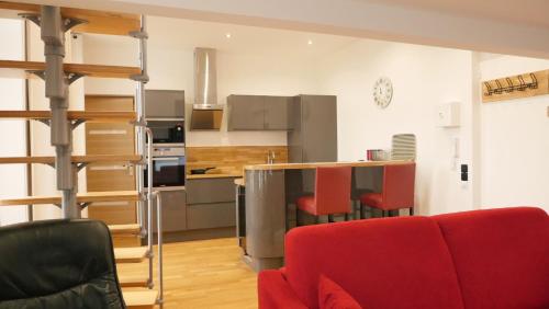 une cuisine avec un canapé rouge et un fauteuil rouge dans l'établissement OPARADI 