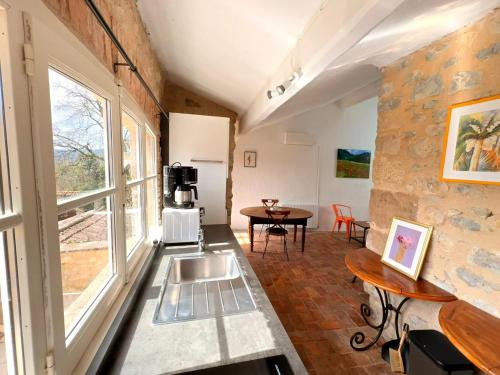 - une cuisine avec un évier et une table dans une chambre dans l'établissement La maison perchée, à Allex