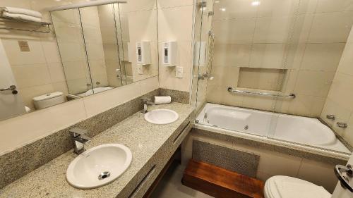 Un baño con lavabo, bañera e inodoro. en Esplendor Flat no Serra Class, en Canela