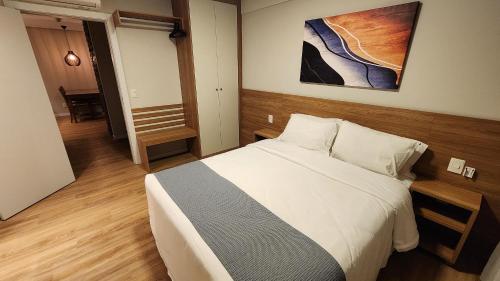 Un dormitorio con una cama y un cuadro en la pared. en Esplendor Flat no Serra Class, en Canela